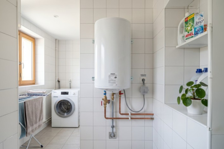 Chauffe-eau électrique installé dans une buanderie moderne avec raccordement apparent