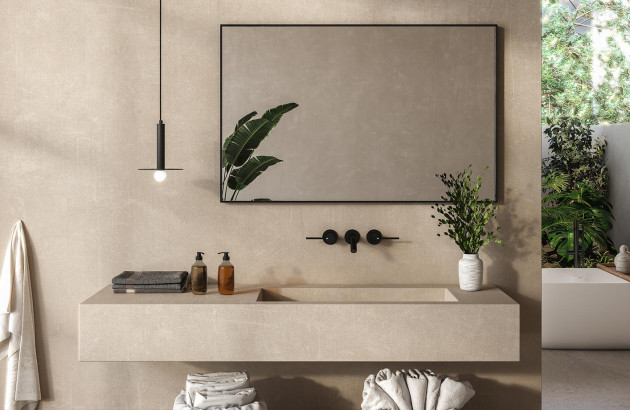 Salle de bains zen avec meuble suspendu beige, robinetterie noire et plantes vertes pour une ambiance apaisante.
